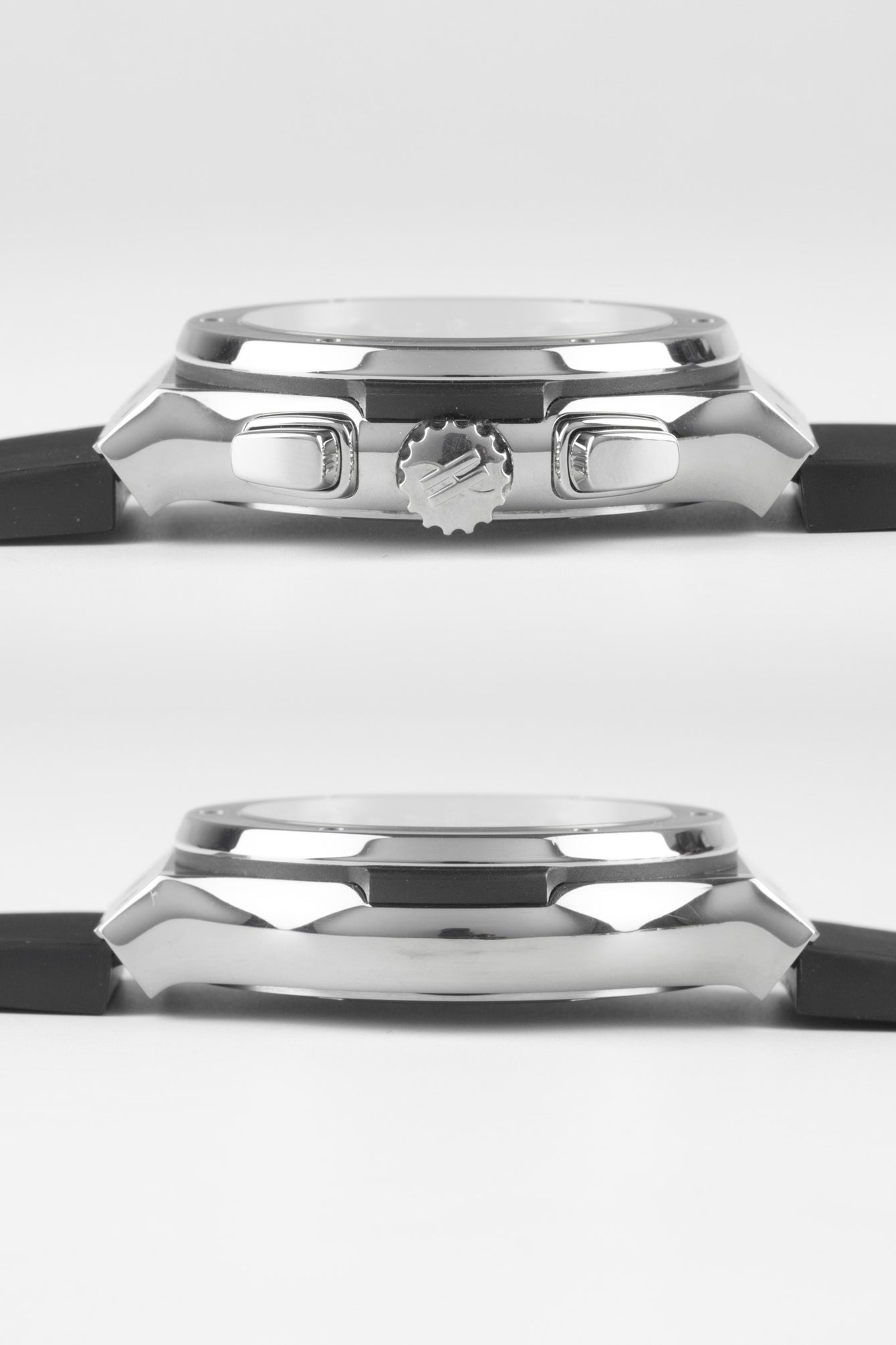 Side profile of a Hublot Classic Fusion chronograph case showing the crown, pushers, and polished steel finish, paired with a black rubber strap against a white background.
