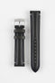 Two black leather watch strap pieces displayed vertically on a light grey background. One strap section features a polished silver buckle with a tang closure and two leather keepers, while the other section shows a tapered end with a row of evenly spaced adjustment holes. The leather has a smooth, slightly grained texture with subtle light stitching near the lugs.