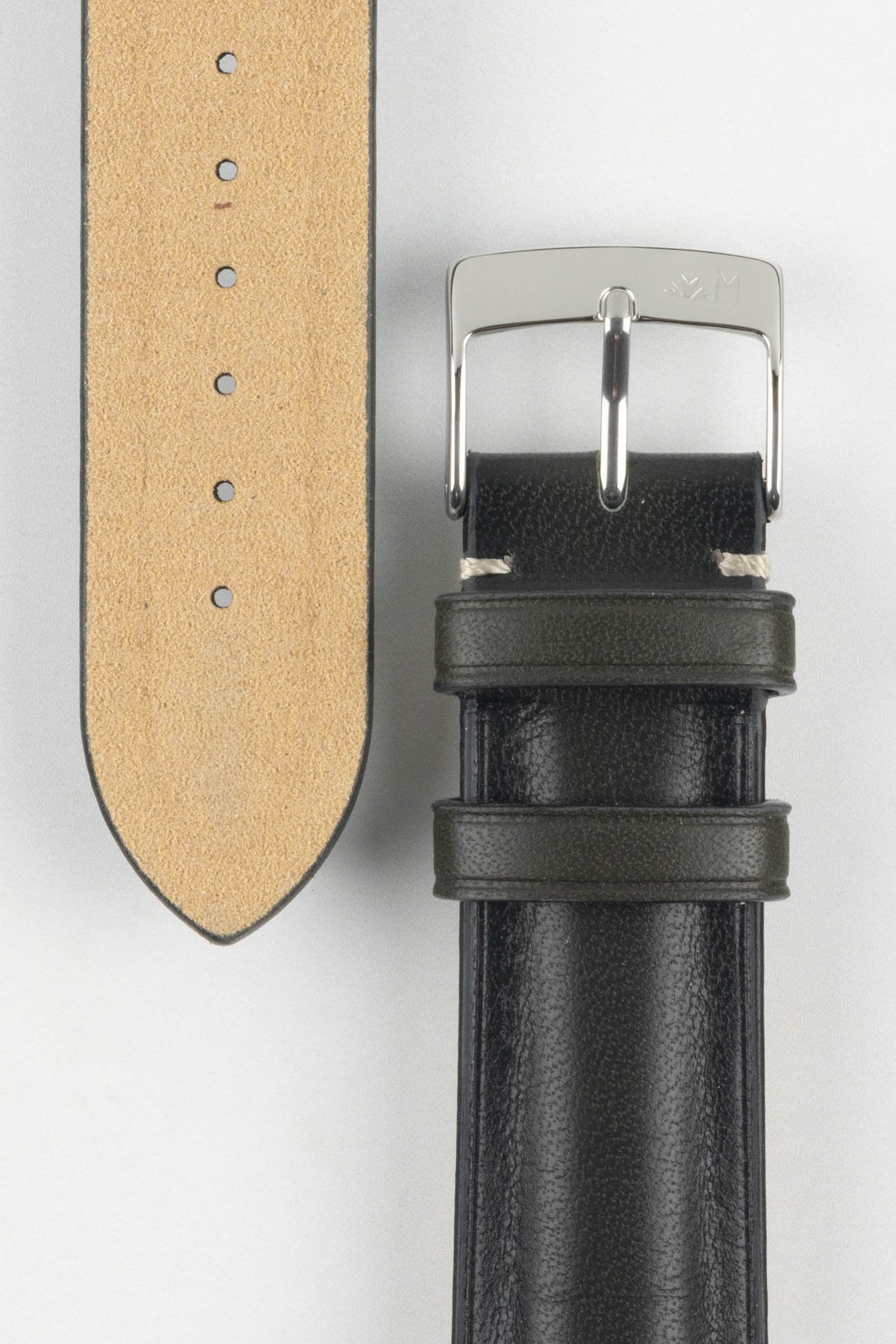 Close-up of two black leather watch strap sections on a light grey background. One section features a polished silver tang buckle with an engraved logo and two leather keepers, while the other shows the underside of the strap in tan suede with a row of evenly spaced adjustment holes. The leather has a smooth, slightly pebbled texture with light contrast stitching near the buckle.