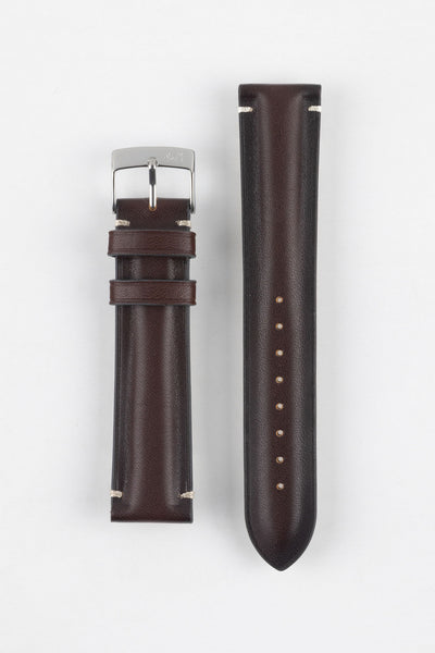 Two burgundy leather watch strap pieces displayed vertically on a light grey background. One strap section features a polished silver tang buckle with an engraved logo and two leather keepers, while the other shows a tapered end with a row of evenly spaced adjustment holes. The leather has a smooth, slightly pebbled texture with subtle light stitching near the lugs, highlighting its refined finish.