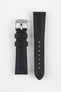 Two black leather watch strap pieces displayed vertically on a light grey background, featuring a matte, slightly textured finish with dark grey stitching. One strap section includes a brushed silver tang buckle with an engraved logo and two leather keepers, while the other shows a tapered end with a row of evenly spaced oval adjustment holes. The clean lines and stitched edges highlight the strap’s durable, contemporary design.
