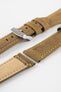 Tan-brown leather watch strap with yellow stitching, shown in angled close-up with a silver buckle, adjustment holes, and beige suede underside.