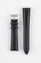 Black leather watch strap with black stitching, shown vertically with a silver buckle and adjustment holes on a light grey background.