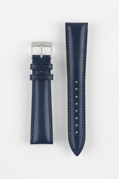 Blue leather watch strap with matching stitching, shown vertically with a silver buckle and adjustment holes on a light grey background.