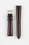 Brown leather watch strap with contrast stitching, shown vertically with a silver buckle and adjustment holes on a light grey background.