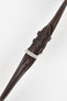Brown leather watch strap with contrast stitching, shown in angled close-up with a silver buckle and adjustment holes.