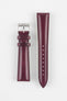 Product shot of a two-piece burgundy leather watch strap laid flat on a plain light background. The strap features a smooth, slightly textured finish with matching burgundy stitching and a gently padded profile. One piece is fitted with a polished silver pin buckle engraved with a small logo, while the other tapered piece displays multiple adjustment holes, highlighting the craftsmanship, stitching detail, and rich leather tone.
