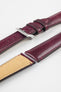 Close-up product shot of burgundy leather watch strap components with matching burgundy stitching and a textured finish. The main strap features perforations and is fitted with a polished silver deployment clasp, while a separate strap piece shows a tan suede underside. All components are arranged on a plain light background to highlight the rich color, stitching detail, perforations, and clasp hardware.