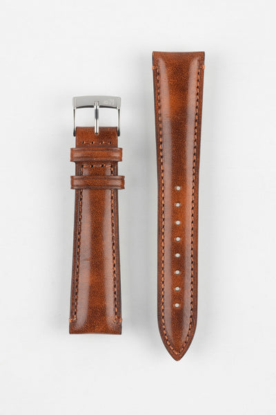 Tan-brown leather watch strap with matching stitching, shown vertically with a silver buckle and adjustment holes on a light grey background.