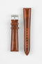 Tan-brown leather watch strap with matching stitching, shown vertically with a silver buckle and adjustment holes on a light grey background.