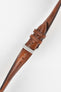 Tan-brown leather watch strap with matching stitching, shown in angled close-up with a silver buckle and adjustment holes.