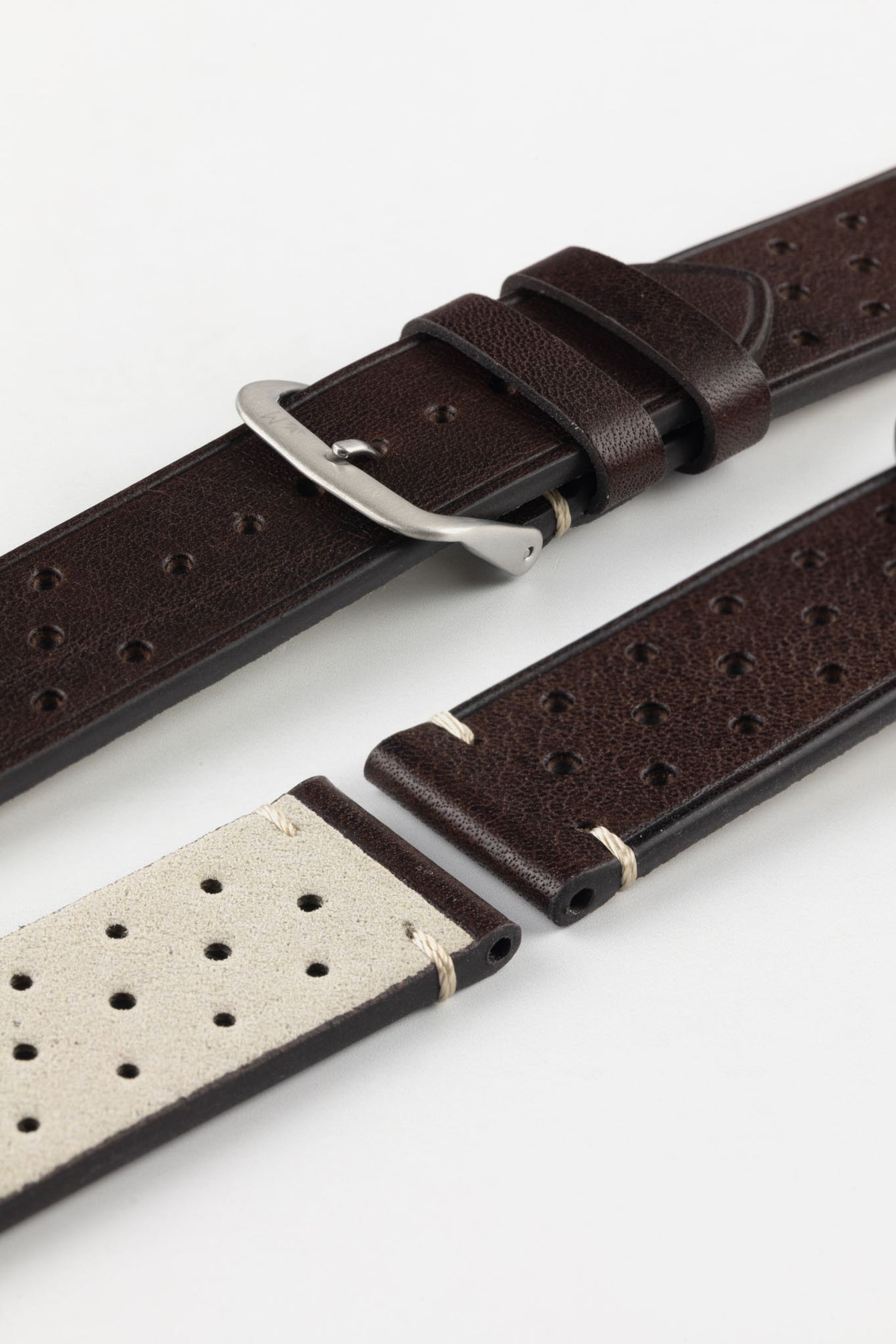A detailed, high-angle shot of a dark brown Morellato Brahms watch strap, unbuckled and laid flat against a white background. The image highlights the perforated design and the beige stitching at the short end, showing the light-coloured lining of the strap.