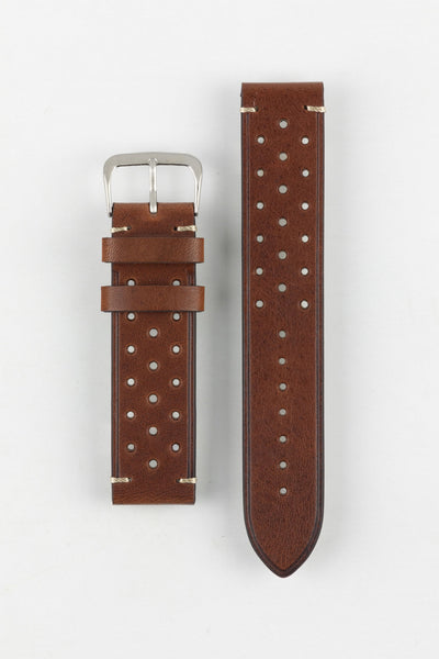 
A high-angle studio shot of a medium brown, 'gold' Morellato Brahms watch strap with beige stitching and a stainless steel buckle, laid flat against a white background. The strap features a rally-style design with two rows of perforations.