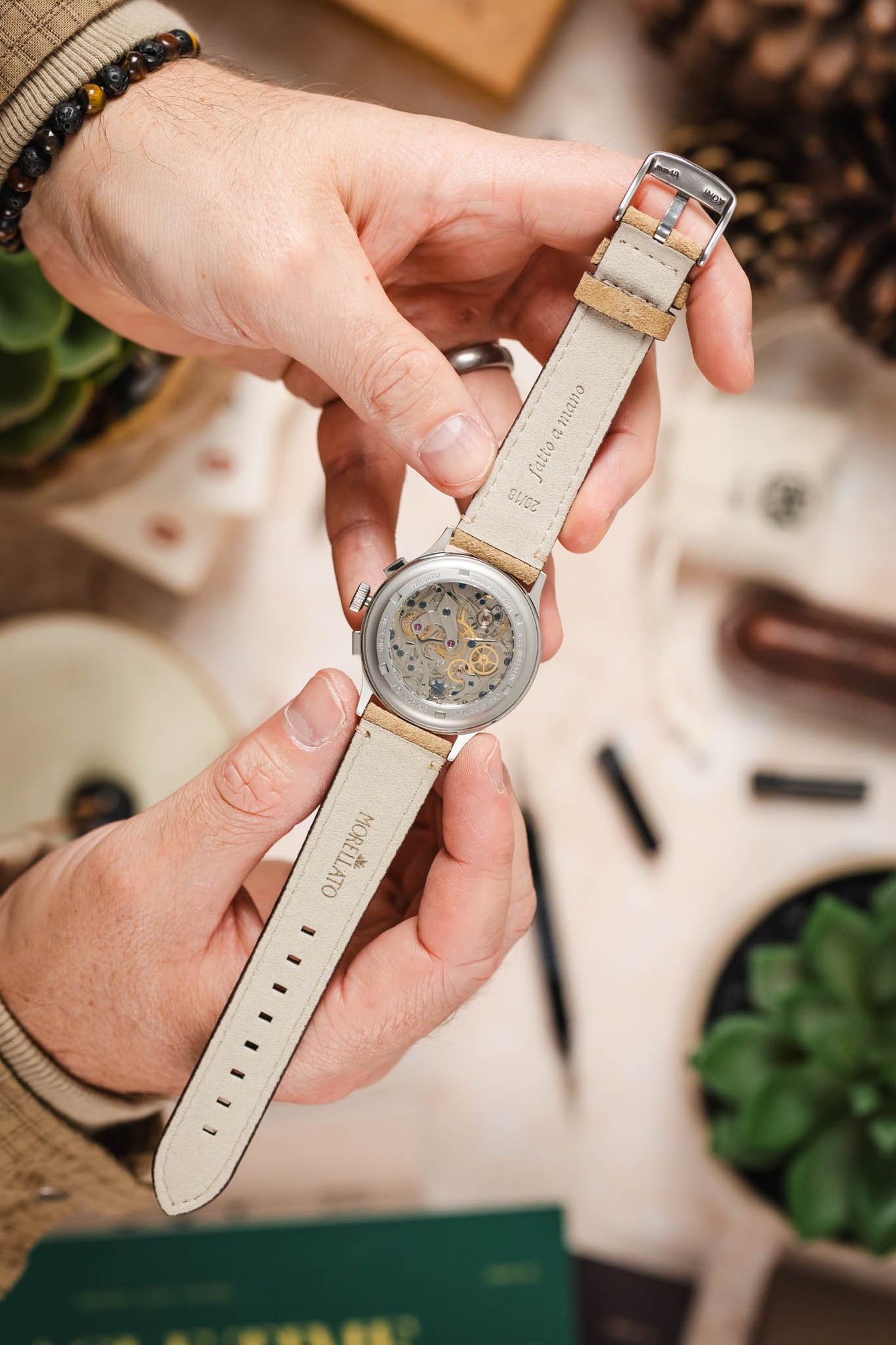 Hands holding Studio Underd0g Bicompax ST-1901 watch with Morellato SCHUMANN beige suede strap. Premium watch strap fitting.