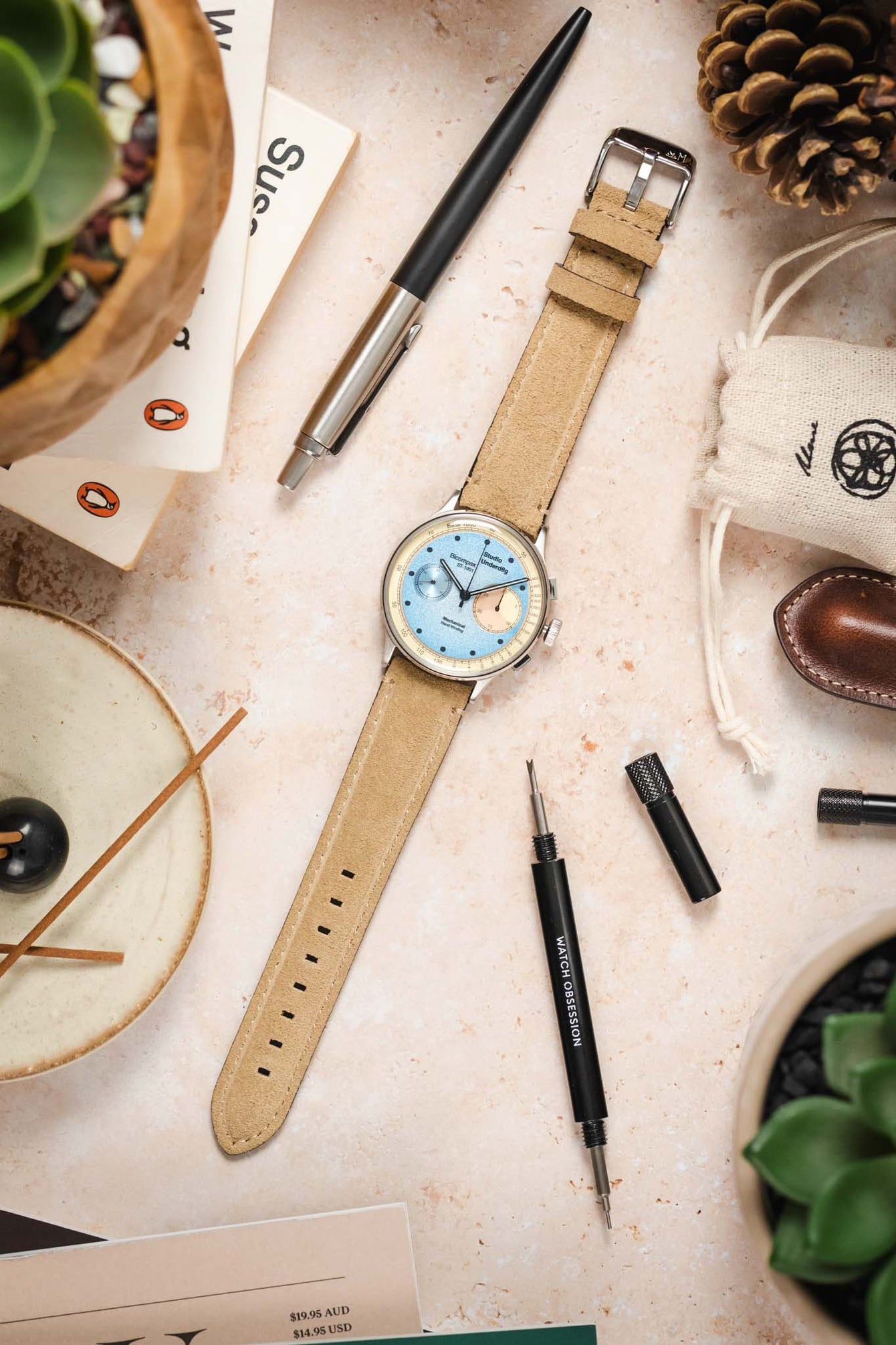 Overhead view of Morellato SCHUMANN beige suede watch strap with Studio Underd0g Bicompax ST-1901 watch, tools, and accessories.