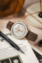 Morellato SCHUMANN brown suede watch strap with Omega MoonSwatch on a table. Classic watch strap options for your collection.