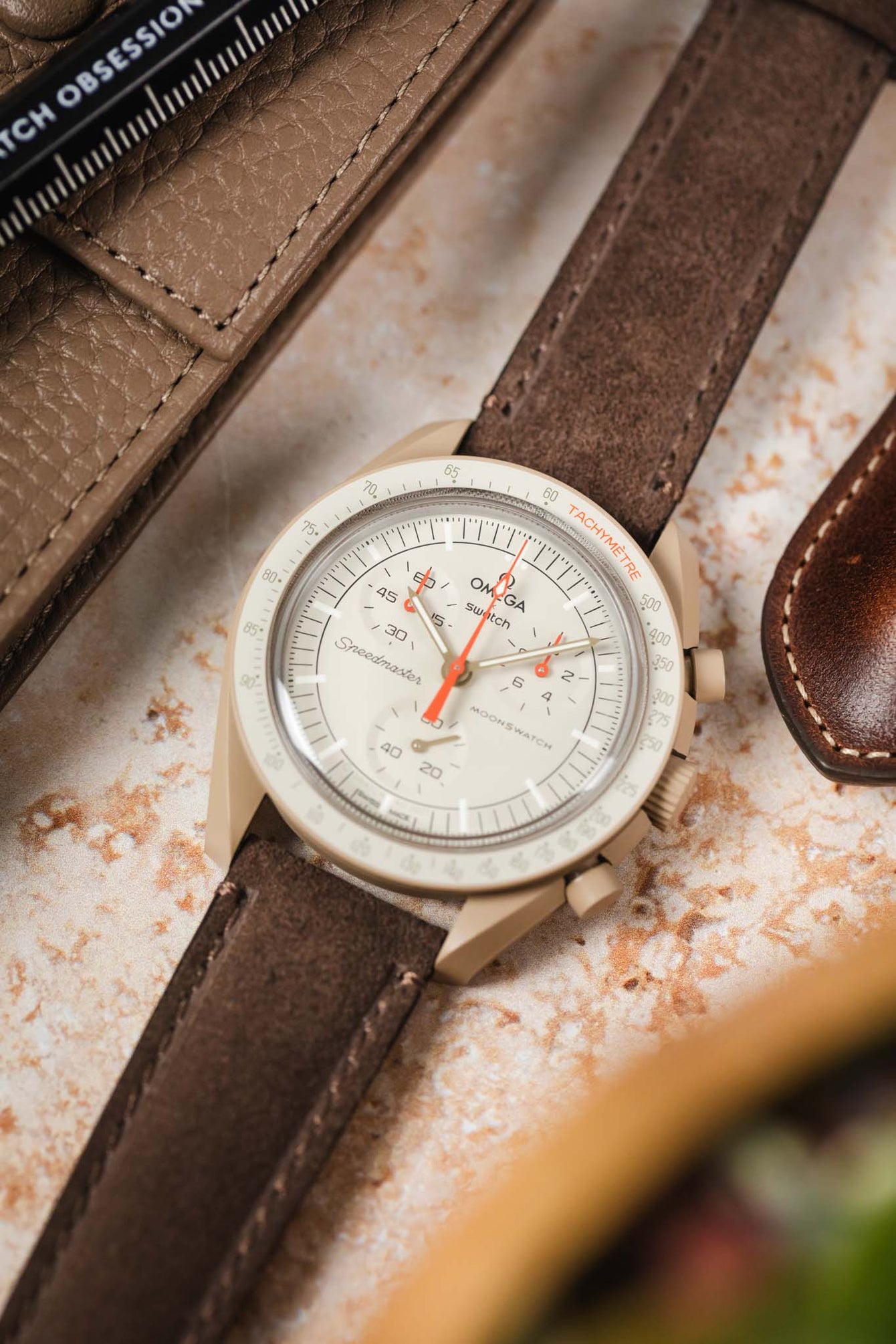 Omega MoonSwatch watch, showcasing the Morellato SCHUMANN brown suede strap. Shop our full range of stylish watch straps.