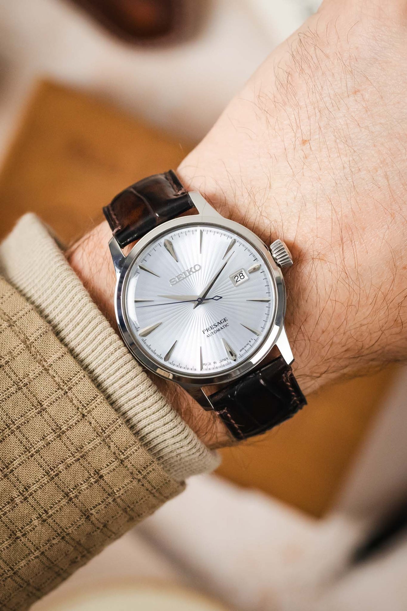 A man's wrist wearing a Seiko watch with the rich brown Morellato Tiepolo watch strap.