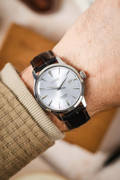 A man's wrist wearing a Seiko watch with the rich brown Morellato Tiepolo watch strap.