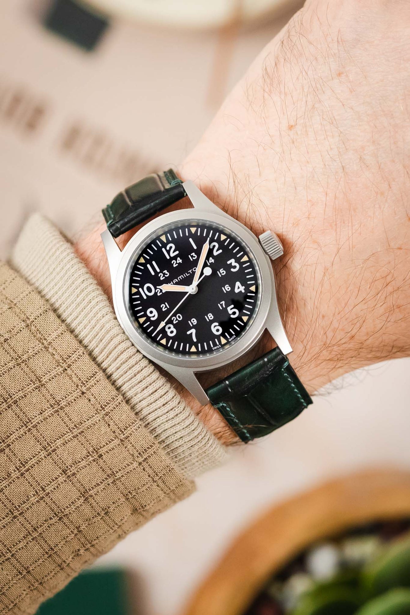 A man's wrist with a Hamilton Khaki Field watch and a sophisticated green Morellato Tiepolo strap.