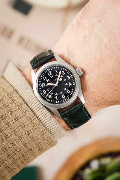 A man's wrist with a Hamilton Khaki Field watch and a sophisticated green Morellato Tiepolo strap.