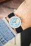 Studio Underd0g Bicompax chronograph watch on a black canvas strap, shown on wrist with a light blue dial and stainless steel case.
