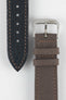 Mocha brown fabric watch strap with a silver-tone RIOS buckle, shown alongside its black leather underside with contrast stitching and adjustment holes.