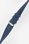 Close-up angled view of an ocean blue fabric watch strap on a light gray background. The strap features a woven textile texture, stitched edges, multiple adjustment holes, and a polished silver-tone RIOS-branded buckle with two matching fabric keepers. The image highlights the strap's durable construction, tapered shape, and refined buckle detailing.