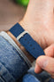 Ocean blue canvas watch strap with a polished RIOS1931 stainless steel buckle, shown on wrist from the underside.