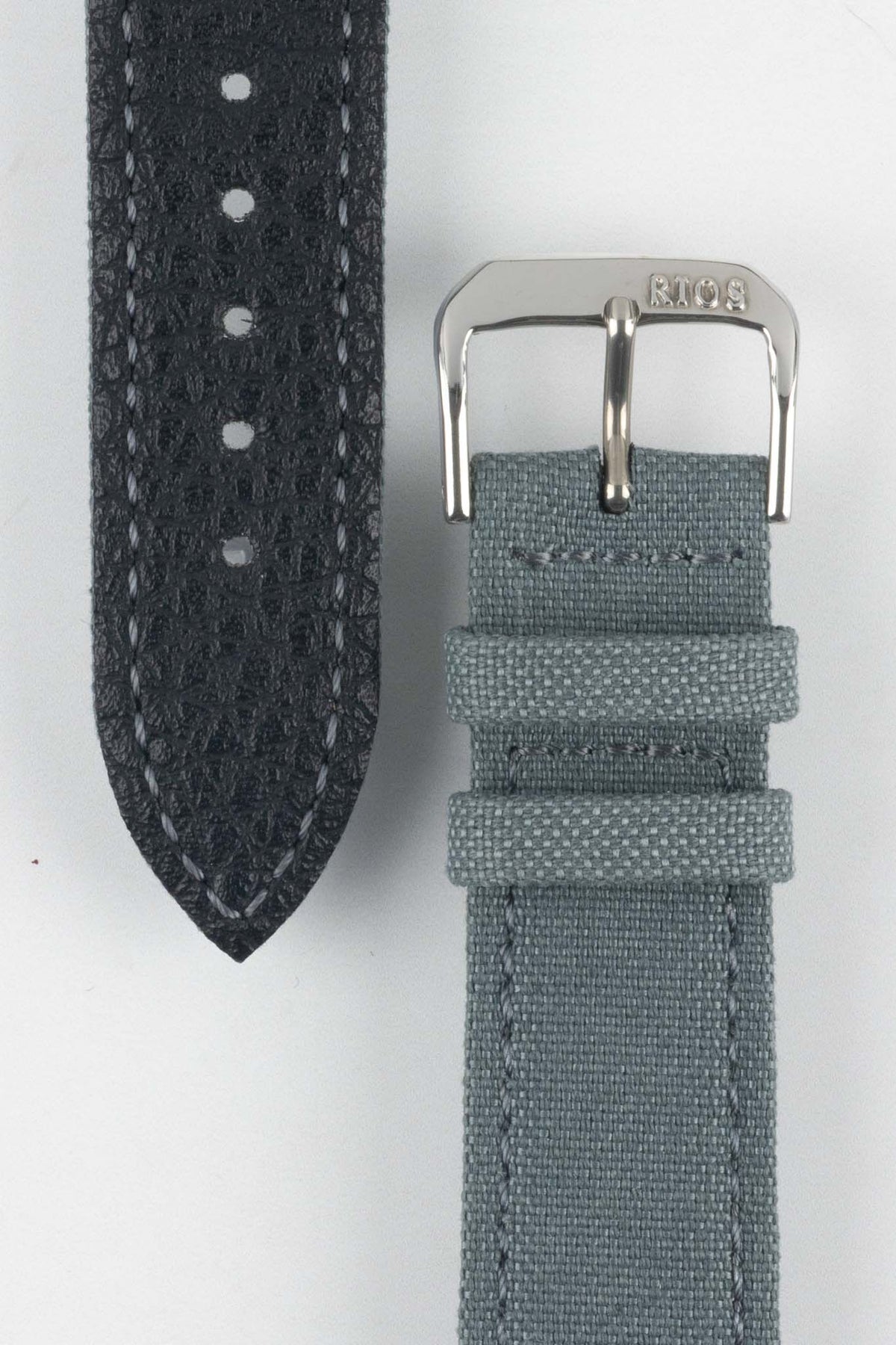 Stone grey fabric watch strap with a silver-tone RIOS buckle, shown alongside its black leather underside with contrast stitching and adjustment holes.