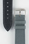 Stone grey fabric watch strap with a silver-tone RIOS buckle, shown alongside its black leather underside with contrast stitching and adjustment holes.