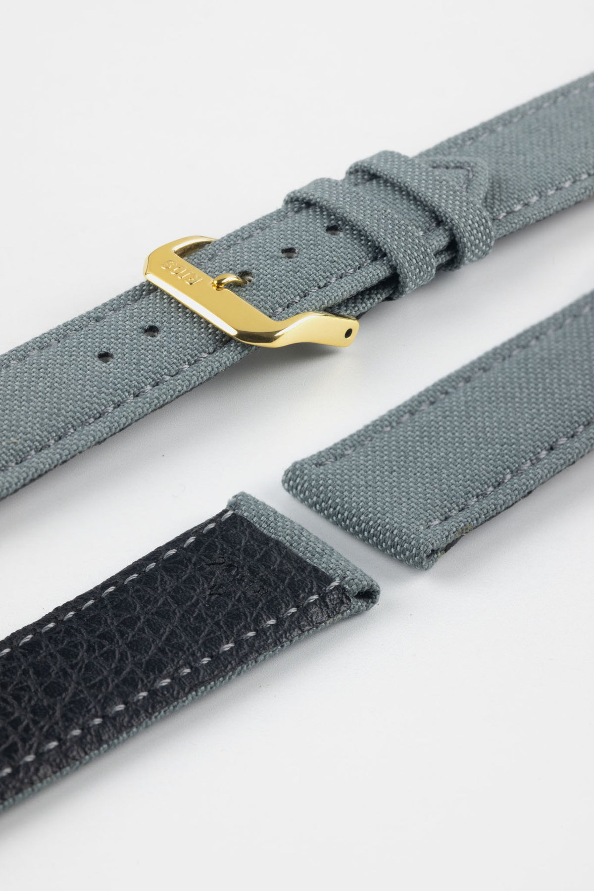 Stone grey fabric watch strap with a gold-tone RIOS buckle, shown with a black leather underside and contrast stitching.
