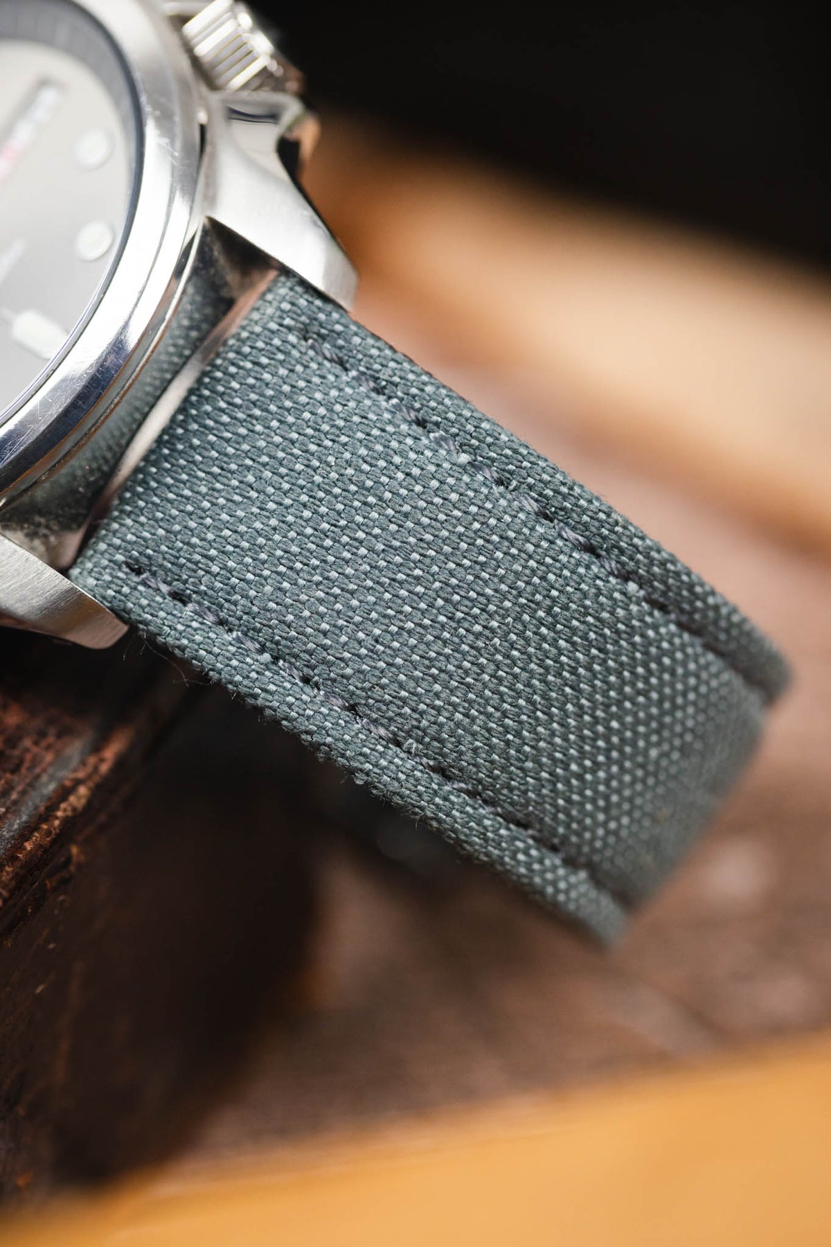 Stone grey canvas watch strap fitted to a Seiko 5 automatic watch, highlighting the woven textile texture and matching grey stitching.