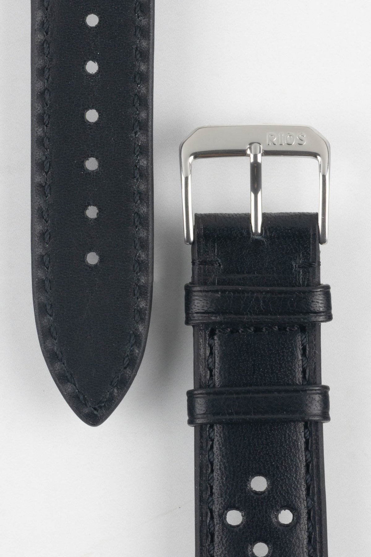 Front and back detail view of a black perforated leather rally watch strap featuring a smooth leather finish, black stitching, a black leather lining, dual keeper loops, and a polished stainless steel RIOS buckle, displayed on a light grey background to highlight the tone-on-tone design, tapered pointed tip, and premium handcrafted construction.