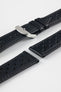 Close-up product shot of black perforated leather watch strap components with matching black stitching, including one fitted with a polished silver deployment clasp. Additional strap sections are arranged on a plain light background, highlighting the leather grain, perforations, stitching detail, and metal clasp hardware.