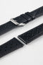 Close-up detail view of a black perforated leather rally watch strap displayed with one strap section detached, featuring black stitching, multiple motorsport-inspired perforations, dual keeper loops, a polished stainless steel RIOS buckle, quick-release spring bars, and a black leather lining. Displayed on a light grey background to highlight the premium handcrafted construction, tone-on-tone detailing, and vintage racing-inspired design.