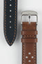 Close-up product shot of a brown perforated leather watch strap paired with a black underside strap segment, both featuring contrast stitching. A polished silver pin buckle is attached to the brown strap, and the components are arranged on a plain light background to highlight the leather texture, perforations, and stitching details.