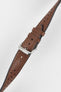Cognac brown perforated leather rally watch strap with matching brown stitching, dual keeper loops, multiple adjustment holes, a polished stainless steel RIOS buckle, and a tapered pointed tip, displayed diagonally on a light grey background to highlight the rich leather finish, vintage motorsport-inspired design, and premium handcrafted construction.