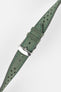 Close-up product shot of a green perforated leather watch strap with contrast green stitching, fitted with a polished silver deployment clasp. The strap is laid diagonally on a plain light background, highlighting the soft suede texture, perforations, stitching detail, and metal clasp.