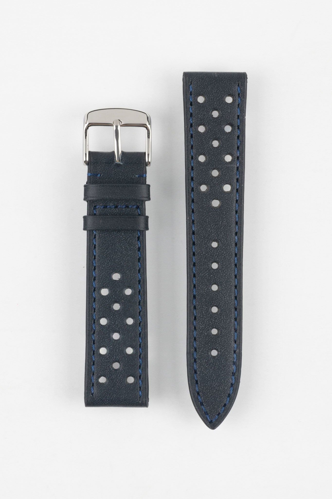 Product shot of a two-piece blue-black perforated leather watch strap laid flat on a plain light background, featuring blue contrast stitching and a polished silver pin buckle on one end.