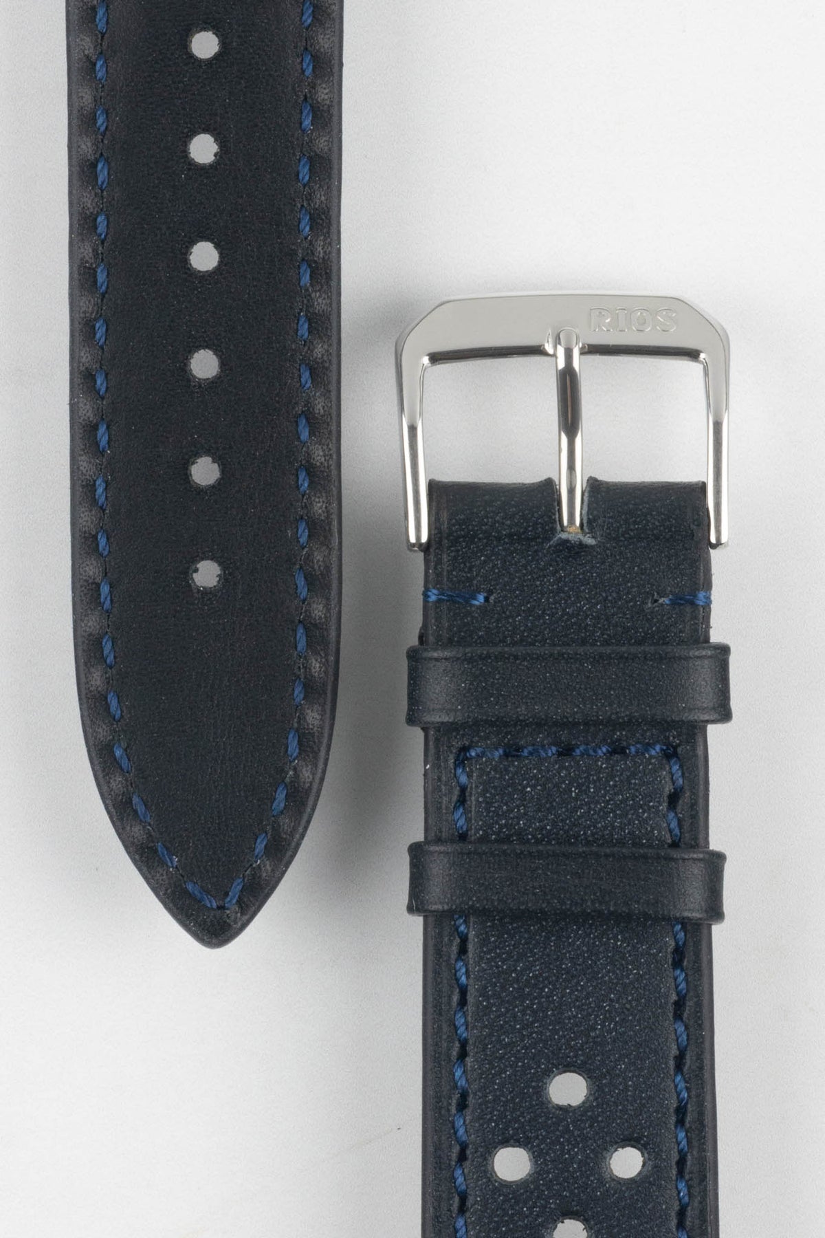 Front and back detail view of an ocean blue perforated leather rally watch strap featuring matching blue contrast stitching, a black leather lining, dual keeper loops, a polished stainless steel RIOS buckle, and a tapered pointed tip. Displayed on a light grey background to highlight the smooth leather finish, motorsport-inspired perforations, contrasting underside, and premium handcrafted construction.