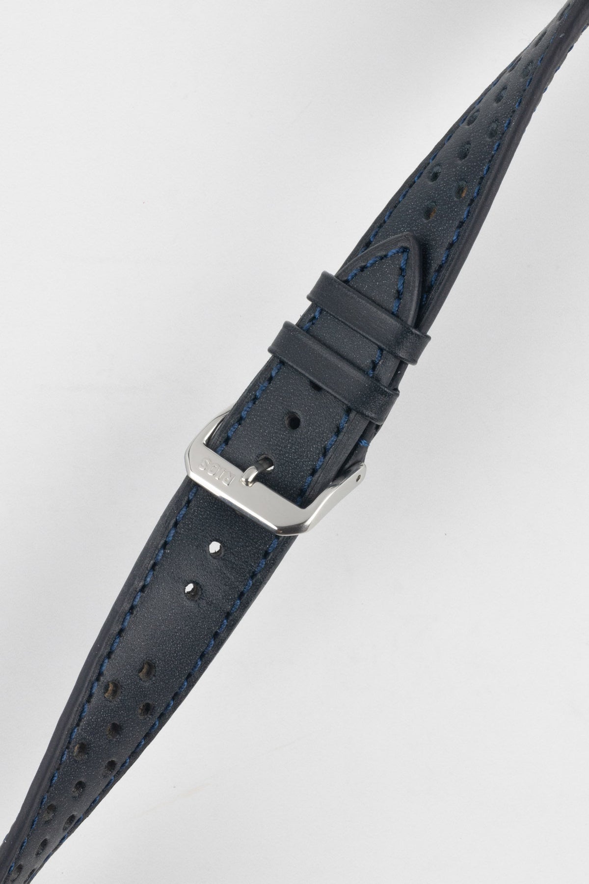 Ocean blue perforated leather rally watch strap with matching blue contrast stitching, dual keeper loops, multiple adjustment holes, a polished stainless steel RIOS buckle, and a tapered pointed tip, displayed diagonally on a light grey background to highlight the smooth leather finish, motorsport-inspired perforations, and premium handcrafted construction.