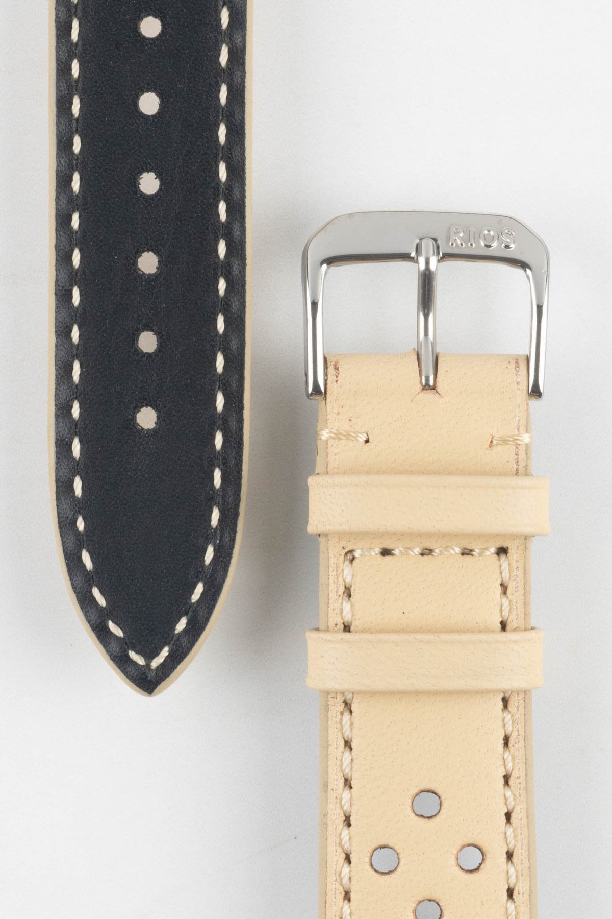 Front and back detail view of a sand-coloured perforated leather rally watch strap featuring cream contrast stitching, a black leather lining, multiple racing-style perforations, dual keeper loops, a polished stainless steel RIOS buckle, and a pointed tapered tip, displayed on a light grey background to highlight the vintage motorsport-inspired design and premium handcrafted construction.