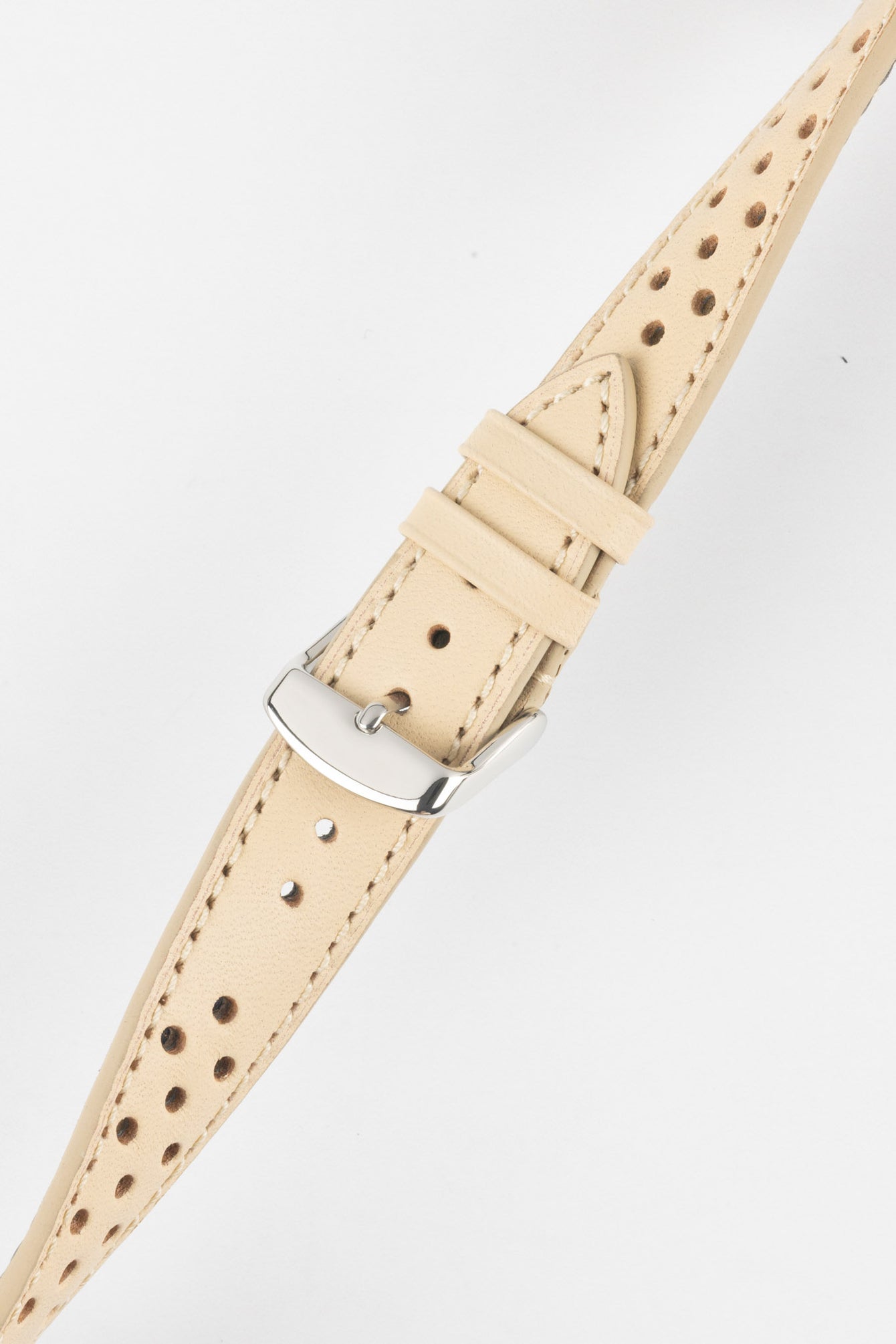 Close-up product shot of a beige perforated leather watch strap with visible stitching and a polished silver pin buckle. The strap is shown laid flat on a plain light background, highlighting the perforation pattern, stitching details, and buckle hardware.
