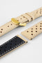 Close-up product shot of beige perforated leather watch straps with contrasting stitching, including one fitted with a polished gold-tone deployment clasp. Additional strap pieces are arranged nearby on a plain light background, showcasing the material texture, perforations, and hardware details.