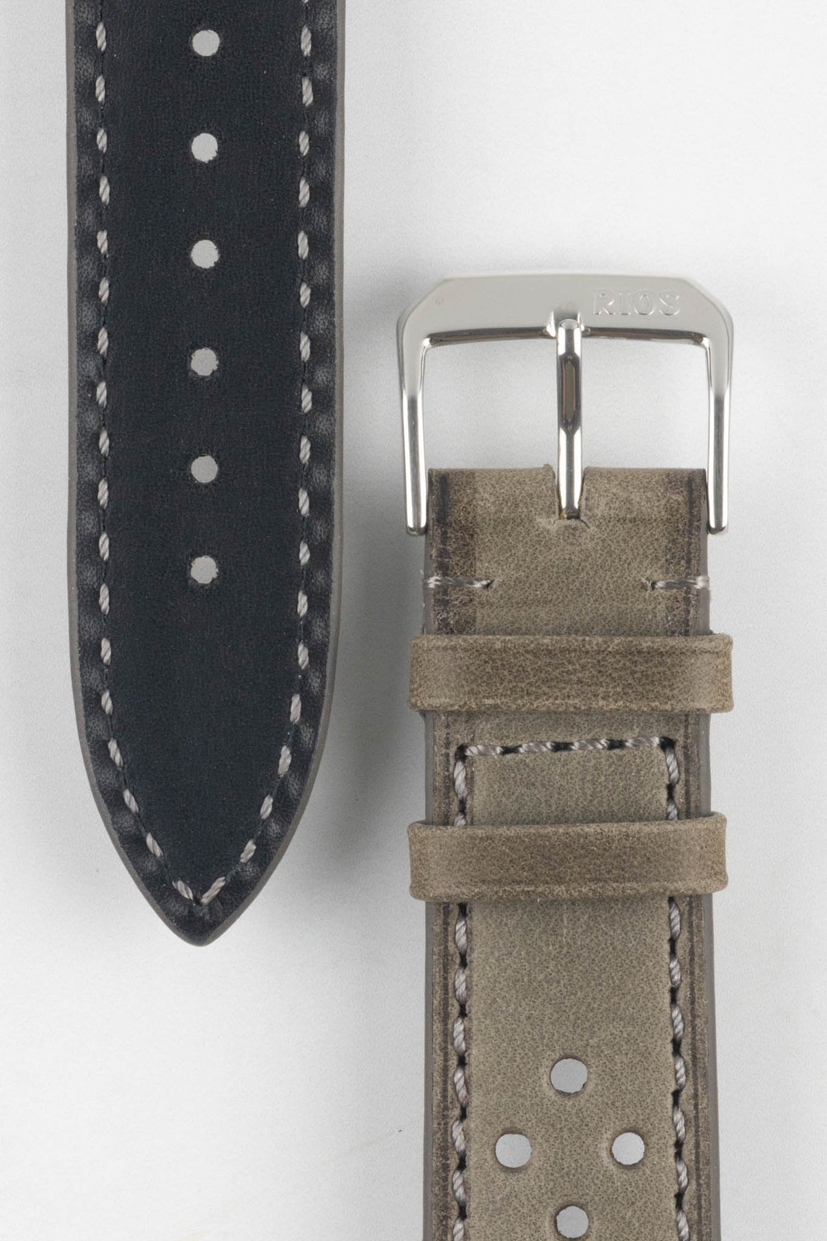 Front and back detail view of a stone grey perforated leather rally watch strap featuring a soft nubuck-style finish, tonal grey stitching, a black leather lining, dual keeper loops, and a polished stainless steel RIOS buckle, displayed on a light grey background to highlight the vintage motorsport-inspired design, contrasting underside, and premium handcrafted construction.