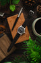 Hamilton Khaki Field Watch lay on a wooden box photographed from above fitted witha Rios 1931 Waging Mocha leather strap