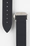 Close-up of a black textured watch strap showing two sections: one with evenly spaced adjustment holes and stitched edges, and the other attached to a polished silver deployant clasp with a subtle engraved logo, set against a light grey background.
