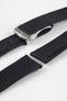 Angled close-up of a black textured watch strap featuring a brushed silver deployant clasp with an engraved logo, alongside separate strap sections with visible stitching and adjustment holes, displayed on a light grey background.
