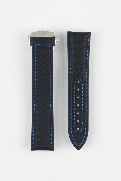 Two black textured watch strap pieces with blue contrast stitching displayed side by side on a light grey background; one strap is attached to a brushed silver deployant clasp with an engraved logo, while the other features a row of adjustment holes.